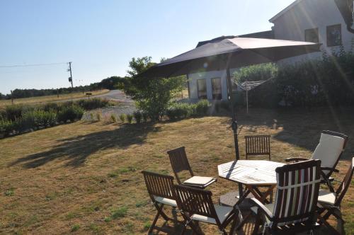 a table and chairs with an umbrella in a yard at Hotel Bella Luna in Båstad