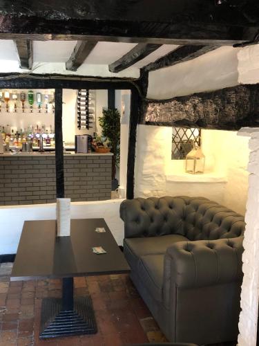 a living room with a couch and a table at Old Hunters Lodge Whipsnade Limited in Whipsnade