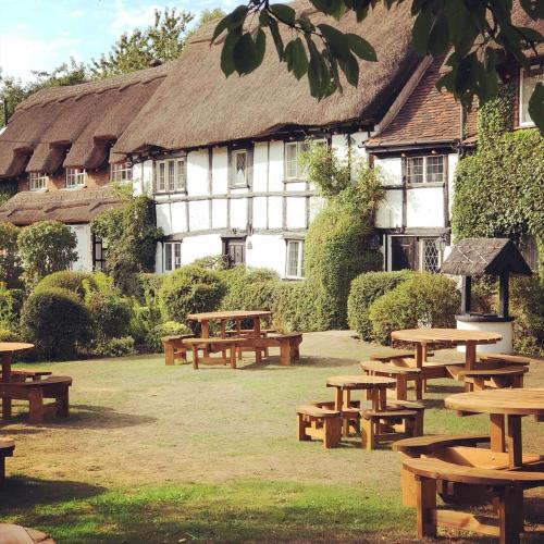 a group of picnic tables in front of a building at Old Hunters Lodge Whipsnade Limited in Whipsnade