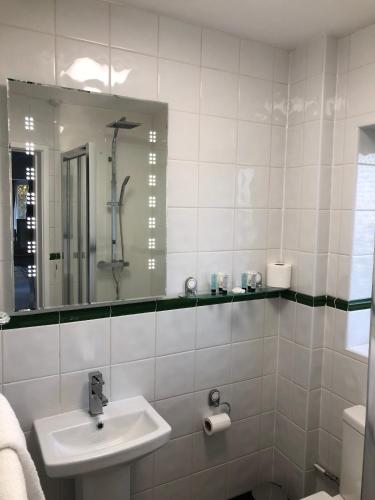 a white bathroom with a sink and a mirror at Old Hunters Lodge Whipsnade Limited in Whipsnade