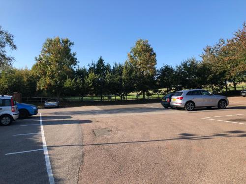 a parking lot with several cars parked in it at Old Hunters Lodge Whipsnade Limited in Whipsnade