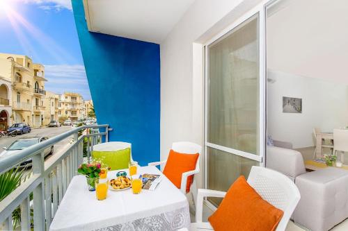 a balcony with a table and chairs on a balcony at Hillock Residence Apartments in Marsalforn