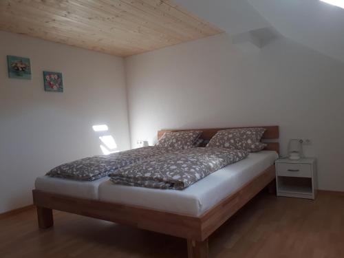 a bedroom with a large bed with a wooden headboard at Ferienwohnung Gmeiner in Hittisau