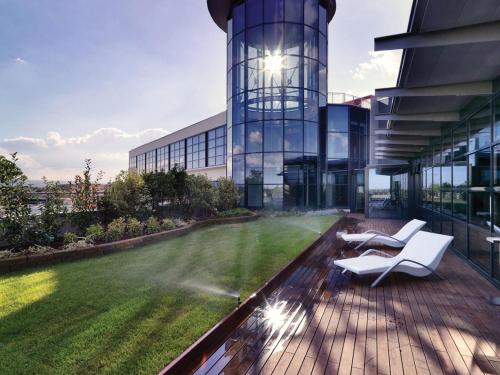 a building with a lawn in front of a building at RMH MODENA DES ARTS in Modena