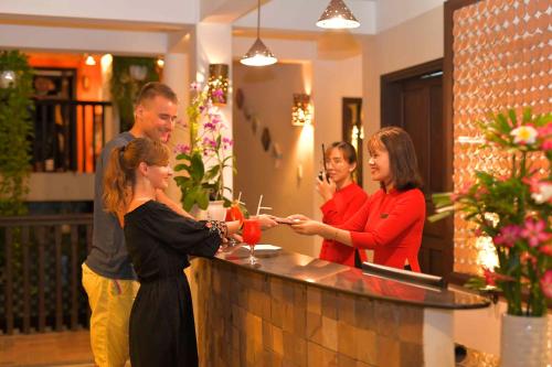 a group of people standing around a bar at Hoi An Ancient House Resort & Spa in Hoi An