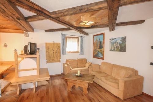 a living room with a couch and a table at Tabià Elisa in Campitello di Fassa