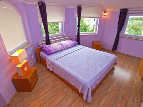 - une chambre violette avec un lit et 2 fenêtres dans l'établissement Apartments Fazanka 1002, à Fažana