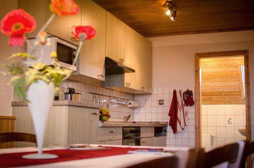 a kitchen with a vase of flowers on a table at Birkholmhof in Bärnau
