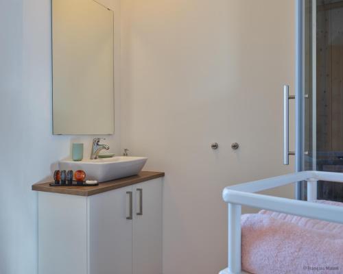 baño con lavabo y armario blanco en La Huche, en Namur