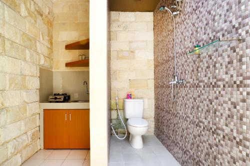 y baño con aseo y ducha. en Lembayung Sari Homestay, en Denpasar