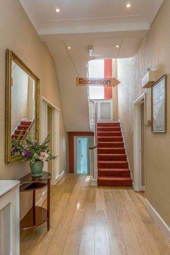 a hallway with a staircase and a mirror at Euro Hotel in London