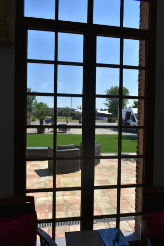 an open window with a view of a patio at Hotel De Pupiter in Kluisbergen