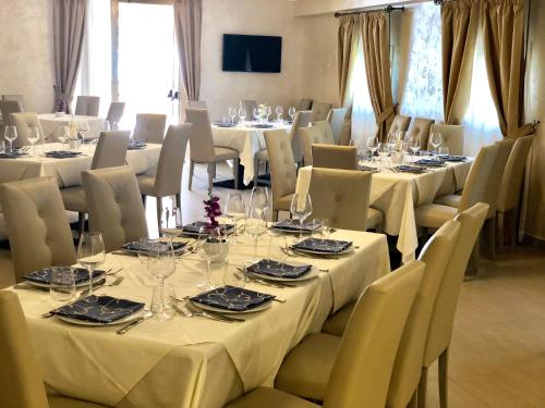a dining room with tables and chairs with white tablecloths at Hotel Riviera Palace in Porto Empedocle