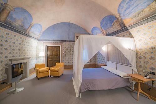 a bedroom with a canopy bed and a tv at Hotel Cavour Et Des Officiers in Bard