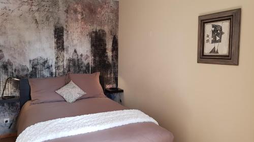a bedroom with a bed with a painting on the wall at Domaine De Pradaous in Reillanne