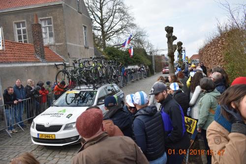 a crowd of people standing around a car with bikes on the roof at Hotel De Pupiter in Kluisbergen