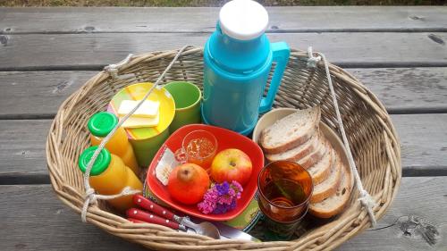 un cesto pieno di frutta e verdura e una bottiglia di Cabanes Sainte Camelle a Saint-Victor-Rouzaud