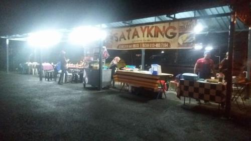 a food stand at night with people sitting at tables at Inapan Desa Homestay Kangar Perlis in Kangar