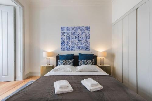 リスボンにあるLovelyStay - Fancy Apartment in the heart of Lisbonのベッドルーム1室(大型ベッド1台、タオル2枚付)