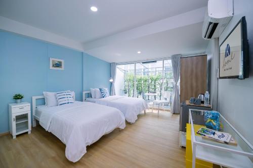 two beds in a room with blue walls at K Home Asok in Bangkok