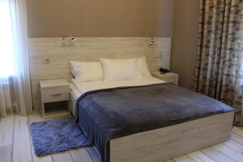 a bedroom with a bed with a wooden headboard at Hotel Aviator in Oryol