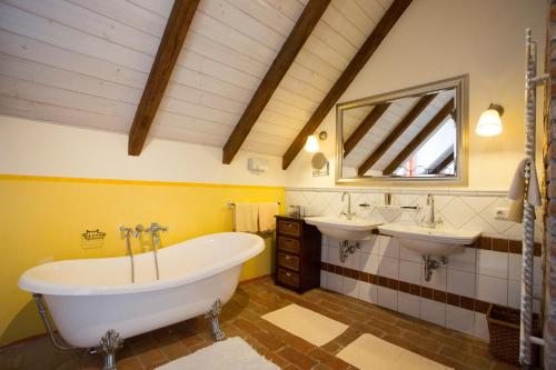 a bathroom with two sinks and a tub and a mirror at Hotel Brummeier in Eferding