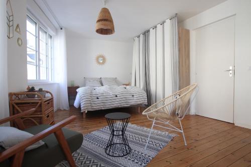 - une chambre avec un lit et une chaise dans l'établissement Grand Studio Bord de Mer, à Saint-Malo