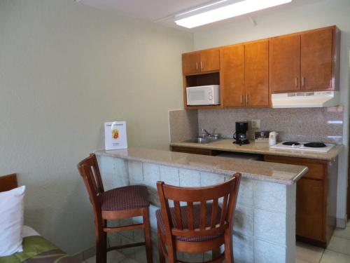 a kitchen with two chairs and a counter in a room at Super 8 by Wyndham South Padre Island in South Padre Island
