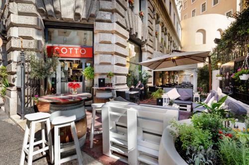 a restaurant on a street with chairs and tables at Dharma Luxury Hotel in Rome