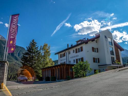 a building with a sign on the side of a road at Hotel Garni Panorama in Scuol