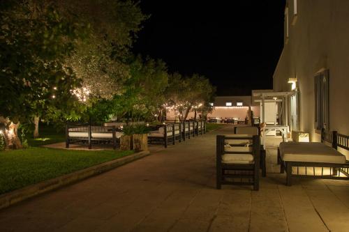 a row of benches next to a building at night at Masseria Montelauro in Otranto