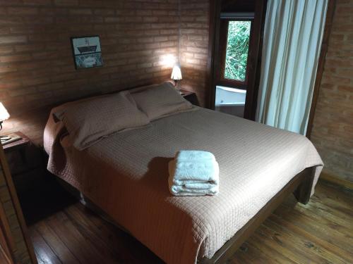 Un dormitorio con cama con una toalla.  en La Camila en Mar de las Pampas