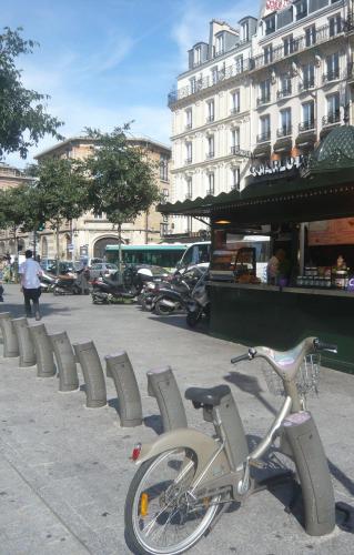 a bike parked on a sidewalk in front of a building at Contact Hôtel Alizé Montmartre in Paris