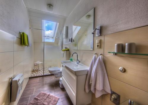 ein Badezimmer mit einem Waschbecken, einem WC und einem Spiegel in der Unterkunft Ferienhaus "Anne" und Weingut Willi Fett in Ellenz-Poltersdorf
