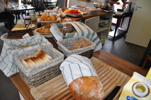 a table topped with baskets of bread and pastries at Hotel Bella Luna in Båstad