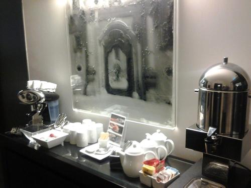 a counter with dishes and a coffee maker on it at Culture Hotel Centro Storico in Naples