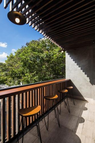 a group of stools sitting on a balcony at Triple E Hotel Fine Art Museum in Ho Chi Minh City