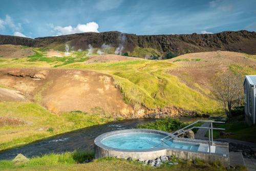 a hot tub on a hill with a waterfall at Frost and Fire Hotel in Hveragerði