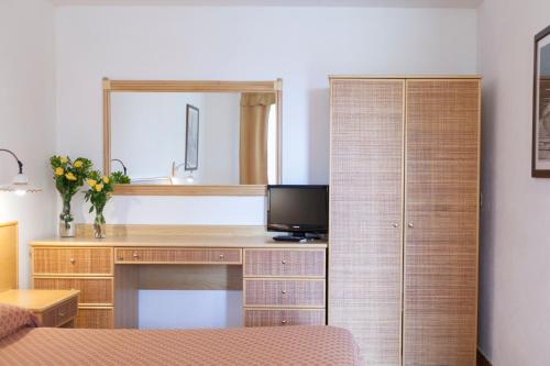 a bedroom with a desk with a television and a mirror at Country House Tre Esse in Assisi