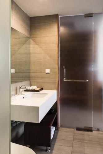 a bathroom with a sink and a shower at Triple E Hotel Fine Art Museum in Ho Chi Minh City