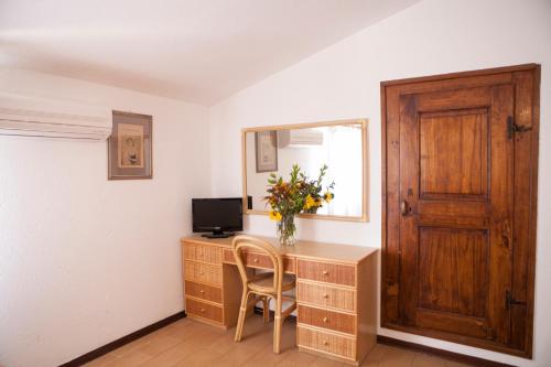a room with a desk with a vase of flowers on it at Country House Tre Esse in Assisi
