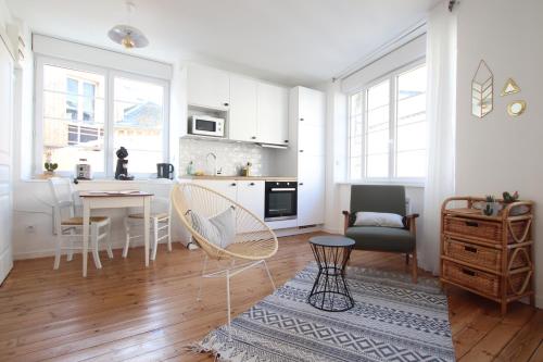 - une cuisine blanche avec une table et des chaises dans l'établissement Grand Studio Bord de Mer, à Saint-Malo