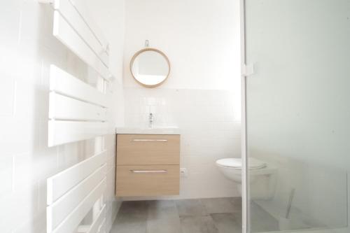 a bathroom with a sink and a toilet and a mirror at Grand Studio Bord de Mer in Saint Malo