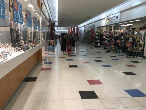 a woman and a child walking through a shopping mall at Darwin City Harbour views-Situated above the OAK Restaurant in Darwin