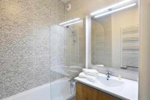 a bathroom with a tub and a sink and a shower at Résidence Néméa Le Marché de la Plage in Mimizan-Plage