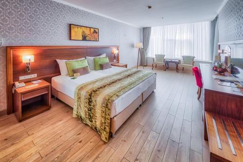 a hotel room with a large bed and a desk at Atakosk Group Hotels in Ankara