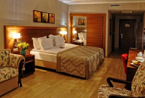 a hotel room with a bed and two chairs at Atakosk Group Hotels in Ankara