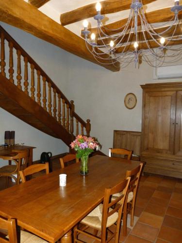 a dining room with a wooden table and a chandelier at Le Grand Gite De La Promenade in Montoire-sur-le-Loir