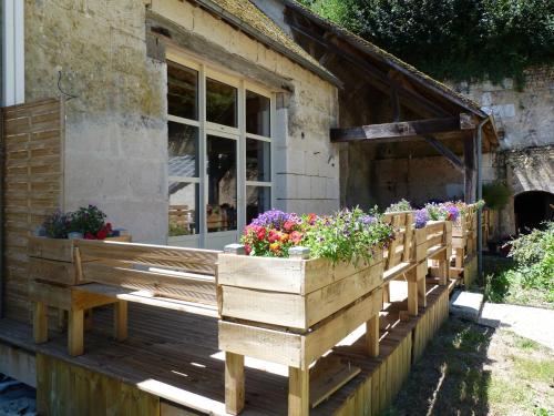 a wooden bench with flowers on a porch at Le Grand Gite De La Promenade in Montoire-sur-le-Loir