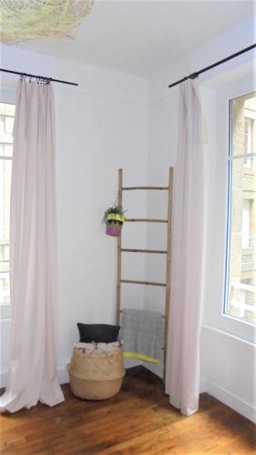 Cette chambre comprend un rideau blanc et une fenêtre. dans l'établissement Le Sainte Barbe, à Saint-Malo